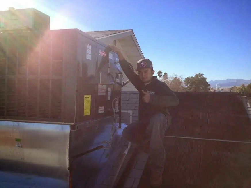HVAC technician performing AC Tune-Up on a rooftop unit in Newberry