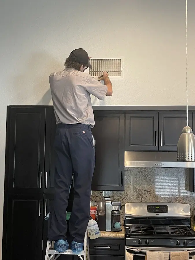 Technician inspecting an air vent during HVAC service in Newberry